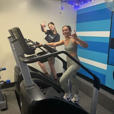 Two members giving a thumbs up on the treadmills