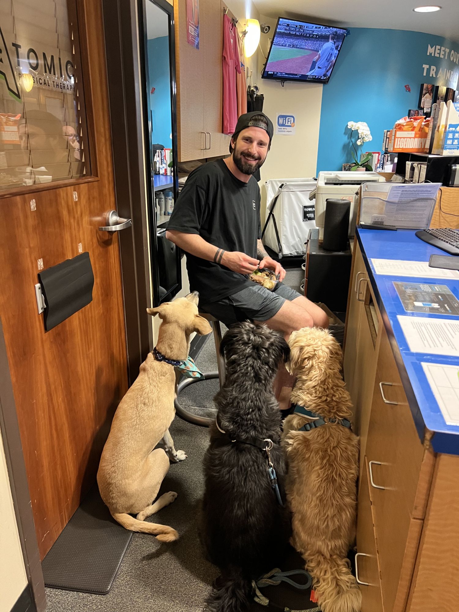 A trainer at the front desk surrounded by member dogs