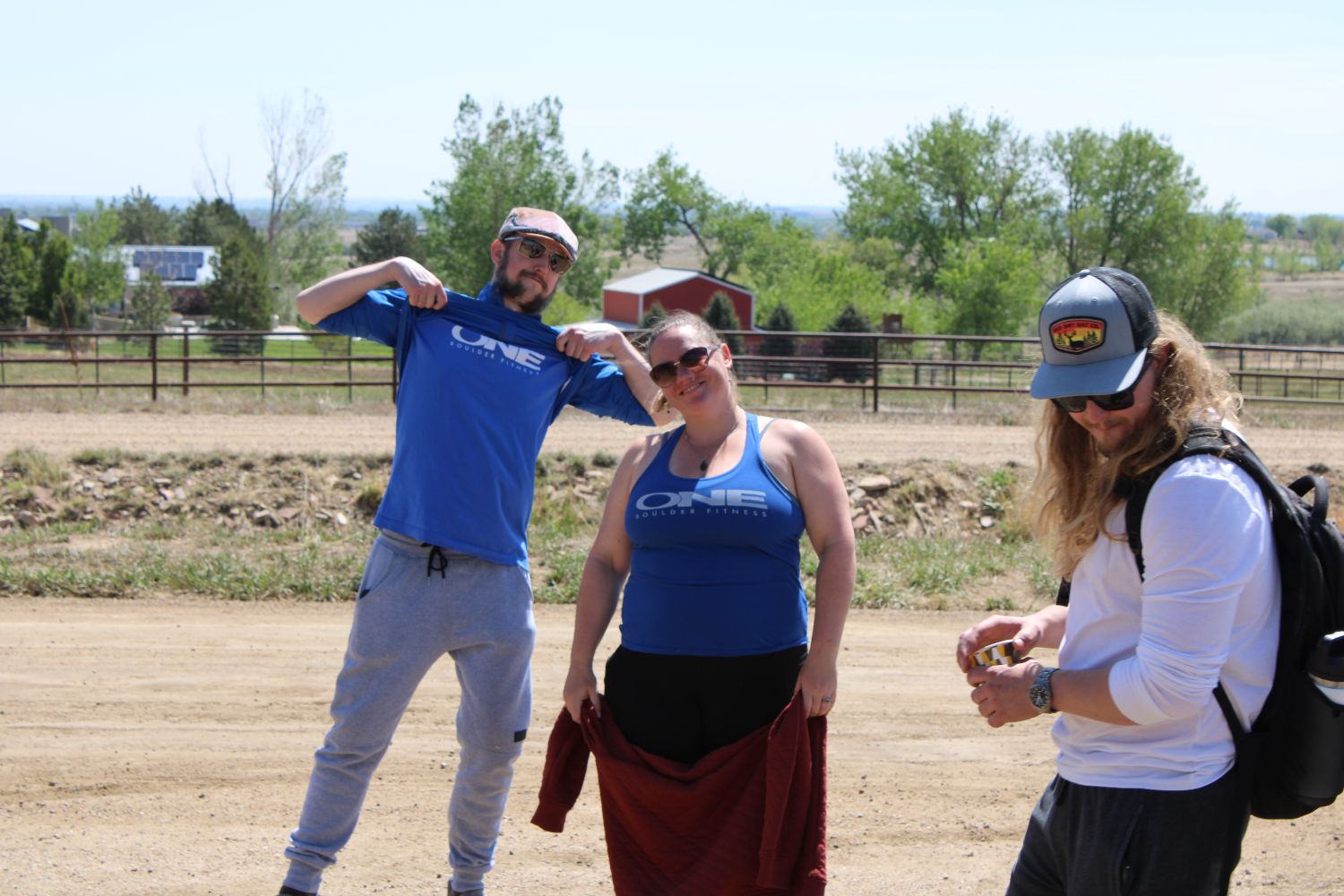 Three members flexing together outside after a session