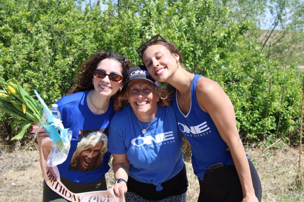 Three ONE Boulder Fitness members squeezed together laughing